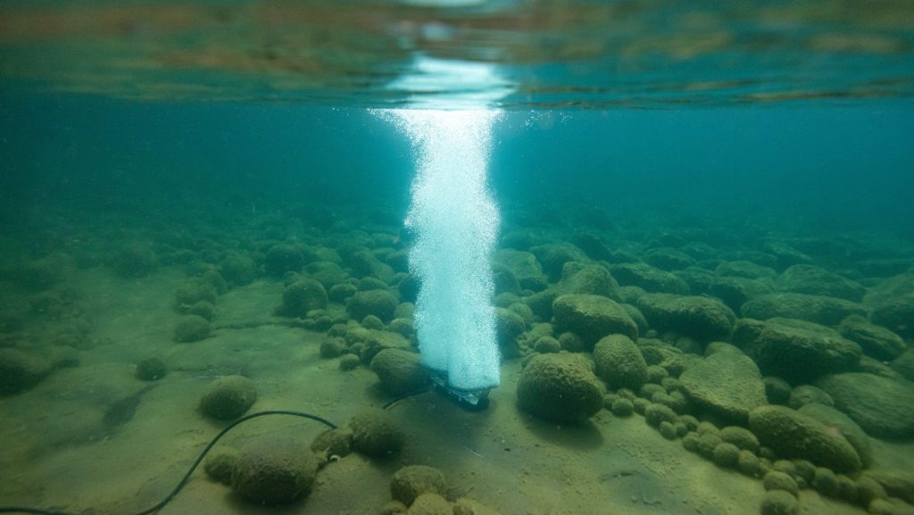 Kasco RobustAire diffused air aeration system releasing bubbles from the pond bottom to increase dissolved oxygen.
